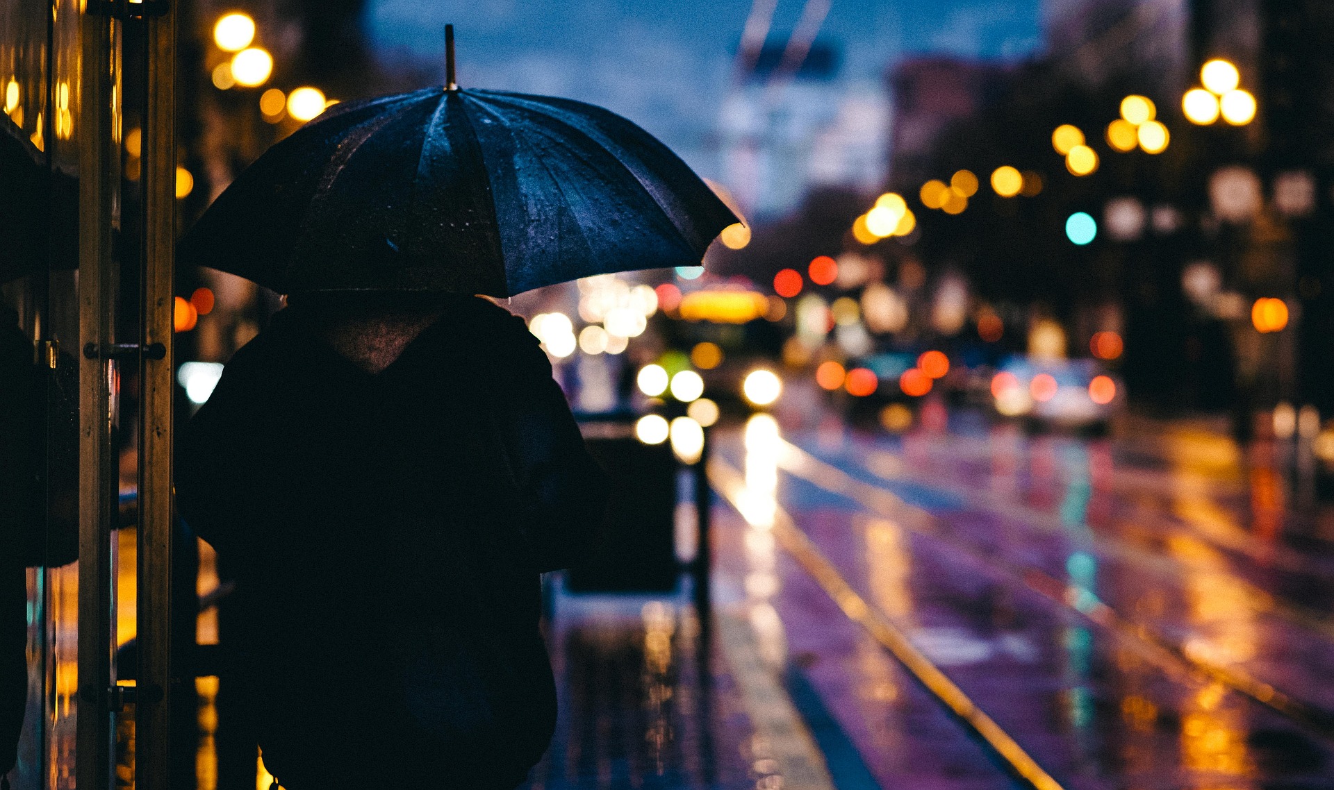 Éjszakában sétáló esernyős ember